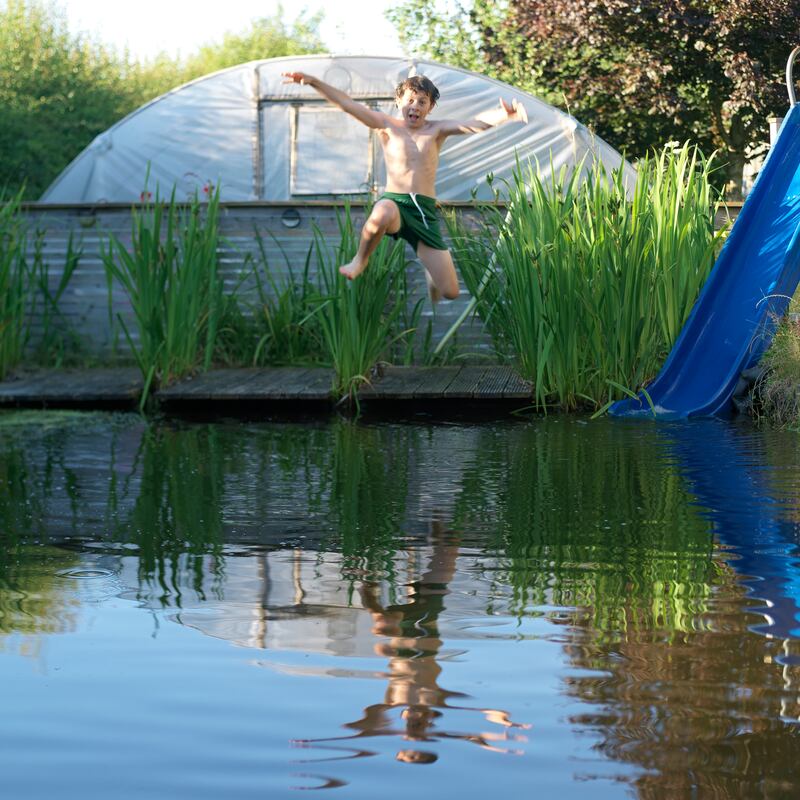 Harry Holland-Rome jumping into the natural swimming pool built by Laois-based artist and permaculturist Marc Rome. Photograph: Richard Johnston