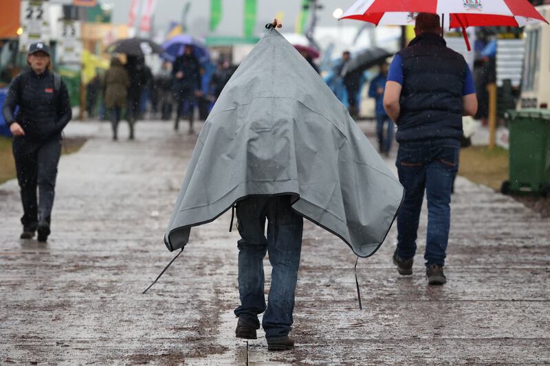 A man takes cover as rain falls during the final day of the National Ploughing Championships. Photograph: Nick Bradshaw