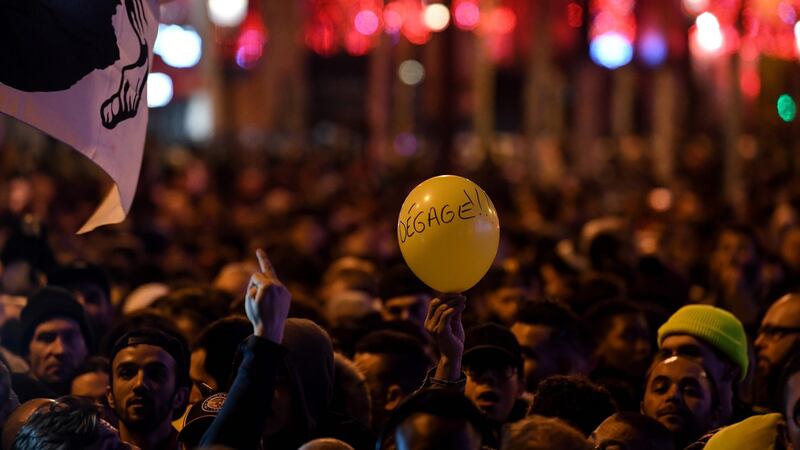 A Corsican flag and a balloon reading “Go away” (meaning Macron) at New Year’s Eve celebrations in Paris.  Photograph: Getty Images