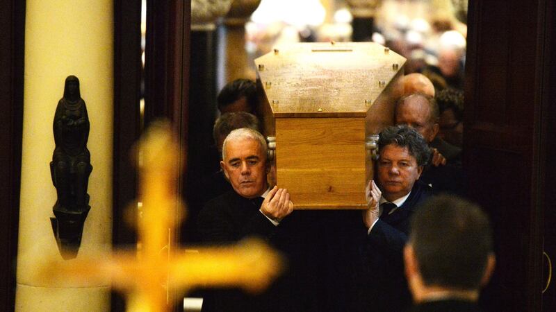 The remains of poet John Montague are carried by his nephews Andrew and Turlough Montague with poet Theo Dorgan (left) at his  funeral mass. Photograph: Alan Betson