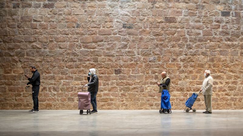 People keep their distance as they wait their turn in a queue to access a supermarket in Barcelona. Photograph: David Ramos/Getty Images