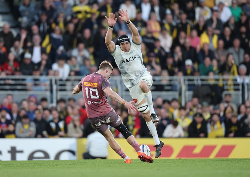 Munster's Jack Crowley scores a drop goal despite the attempt of La Rochelle's Ultan Dillane to block the kick. Photograph: Billy Stickland/Inpho