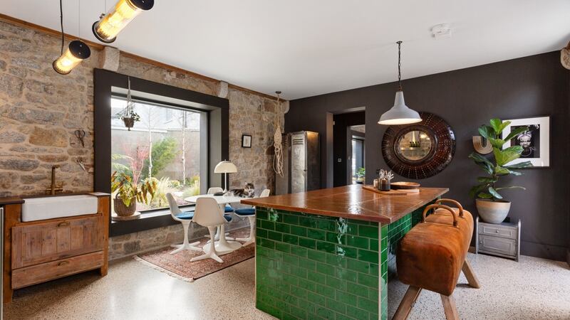The kitchen island at Glandore Mews has a beaten-copper top and shamrock-green, open-tiled shelving below