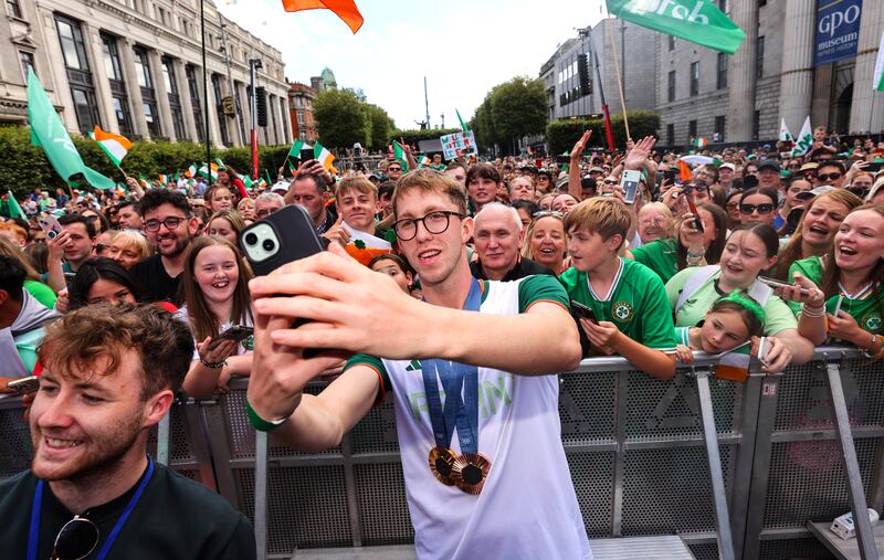 Daniel Wiffen takes a selfie with fans while wearing his gold and bronze medals for the men’s 800m and 1500m freestyle Photograph:  
INPHO/Ben Brady