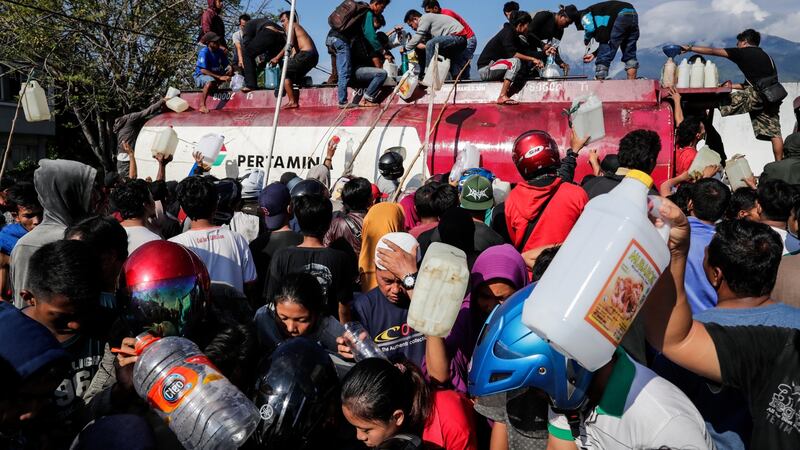 People scramble to get fuel from a fuel truck at a gas station in Palu. Photograph: Mast Irham/EPA