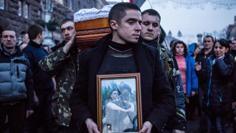 The body of Ustim Holodnyuk (19), who was killed in fighting between anti-government protesters and police, is carried from Independence Square in Kiev yesterday. Photograph: Brendan Hoffman/Getty Images