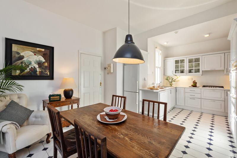 The kitchen-diner has white timber units and smart tiled floors