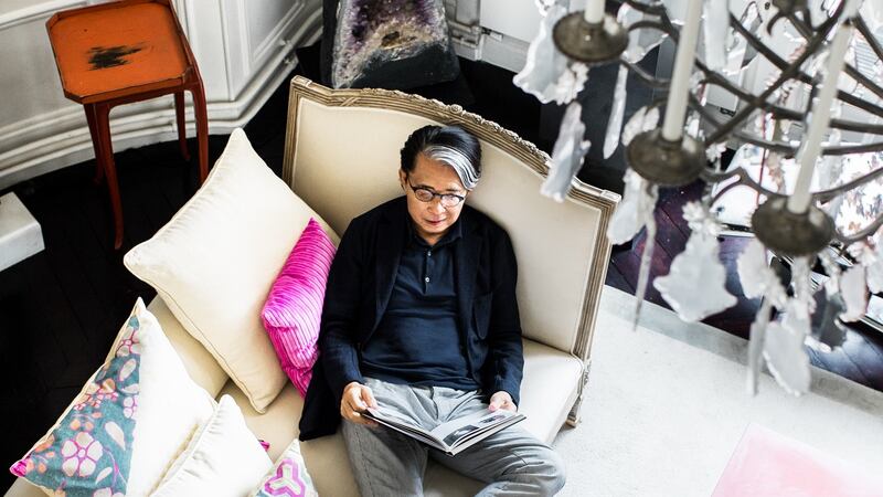 Kenzo in his apartment where  a  group of sketches by Jean Cocteau hang on one wall and a huge cathedral church amethyst geode that he bought in Brazil stands in a corner. The sofa he sits on is by French design studio Christian Liaigre and you can see a Japanese red lacquer tray in the negoro-nuri tradition behind him. Photograph: Eric Matheron-Balay