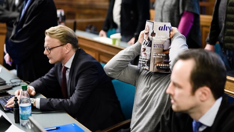 One of the four defendants holds a magazine in front of his face in the courtroom in Berlin on Thursday, at the start of their trial for the theft of a 100kg gold coin froim a museum in 2017. Photograph: Clemens Bilan/EPA