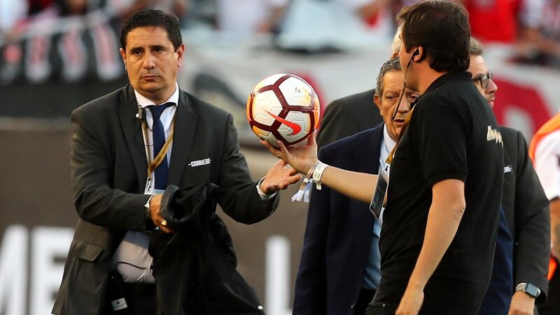Officials remove the matchball after the match was postponed. Photograph: Marcos Brindicci/Reuters