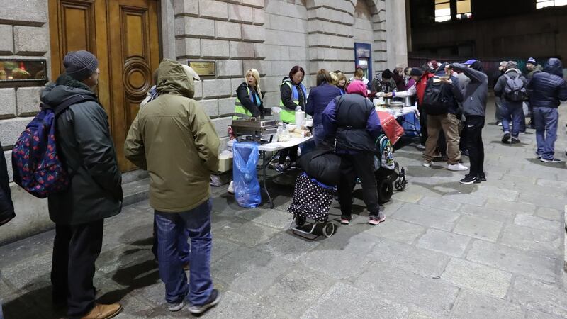 Families queue up at The Lending Hand, a soup kitchen feeding up 300 people every Monday evening on College Green in Dublin city centre. Photograph: Niall Carson/PA Wire e
