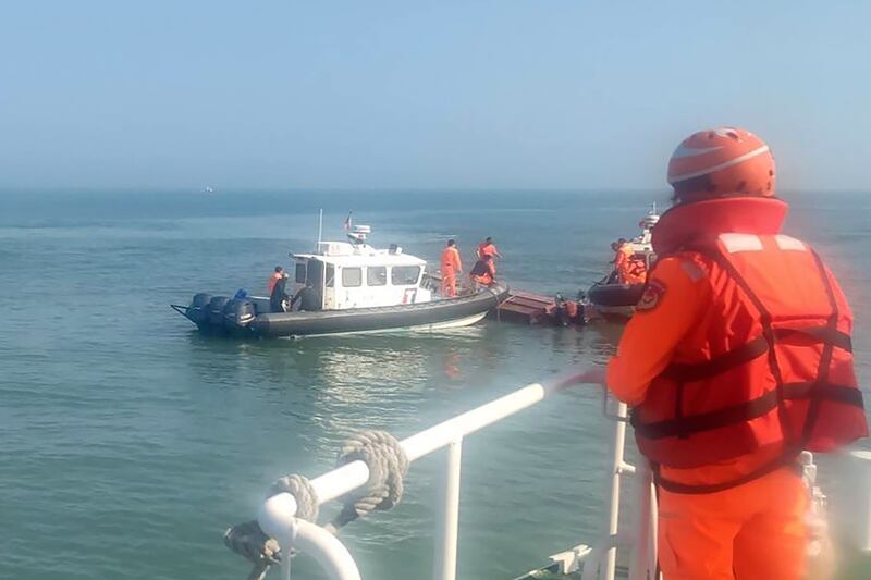 Taiwanese coast guards inspecting the vessel that capsized during a recent chase off the coast of Kinmen archipelago. Two Chinese fishermen died following the incident. Photograph: Taiwan Coast Guard Administration via AP