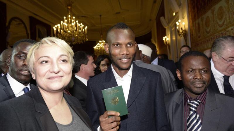 Lassana Bathily, a man of Malian origin described as a “hero” after he helped hostages at a Jewish supermarket hide during last week’s Paris attacks, holds his French Passport following a ceremony at which was awarded French nationality in Paris on January 20th, 2015. Photograph: Eric Feferberg/AFP/Getty Images