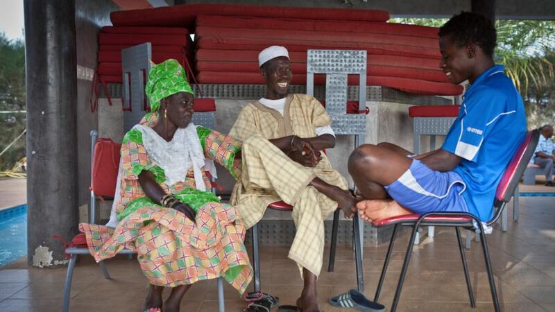 Abdoulaye Sall (16) gets a visit from his his parents, Adama Bah and Douda Sall, at the Aspire Football Dreams soccer academy in Saly, Senegal on June 3rd, 2014. Photograph: Jason Florio/The New York Times)