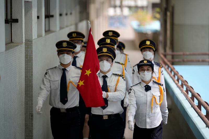 Students attend a Chinese national flag raising ceremony during at a secondary school to mark the 25th anniversary of Hong Kong handover to China (AP)