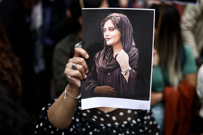A protester holds a portrait of Mahsa Amini during a demonstration in front of the Iranian embassy in Brussels on September 23rd. Photograph:  Kenzo Tribouillard/AFP via Getty Images