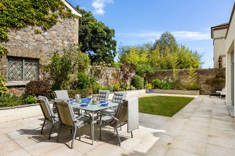 The back garden has a large patio and border planting