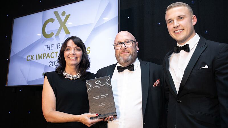 Jenny McCoy, awards judge, presents the CX Impact in Technology, Media & Telecoms award to Patrick Cotter and Evan Cotter, Rural WiFi.
