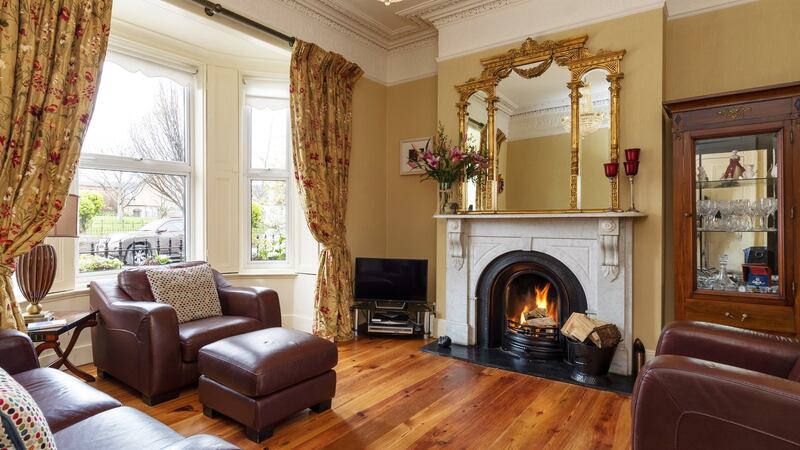 The sitting room has a white marble fireplace and restored pitch pine floor