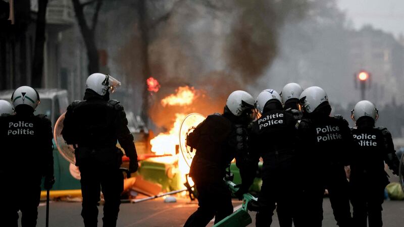Belgian riot police stand in position as clashes erupt during a demonstration against the government’s measures to curb the spread of Covid-19,  in Brussels. Photograph: Kenzo Tribouillard/AFP via Getty Images