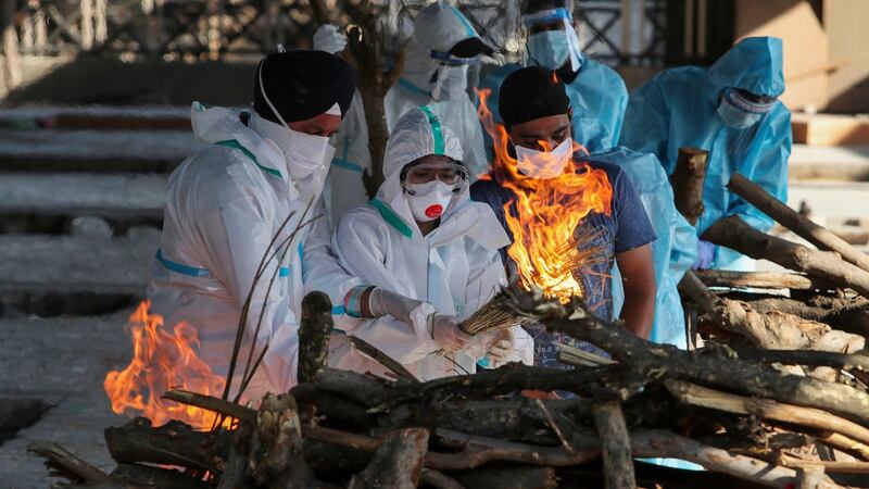Family members of a person who died due to Covid-19 light the funeral pyre at a crematorium in Jammu, India. Photograph: Channi Anand/AP