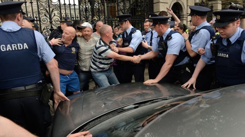 Gardai move protesters to allow a  car entry from Kildare Street on Wednesday.  Photograph: Dara Mac Dónaill/The Irish Times