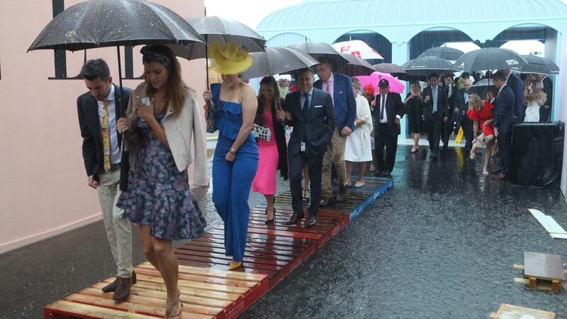 Racegoers make their way into the Birdcage through a flooded entrance. Photo: Dave Crosling/EPA