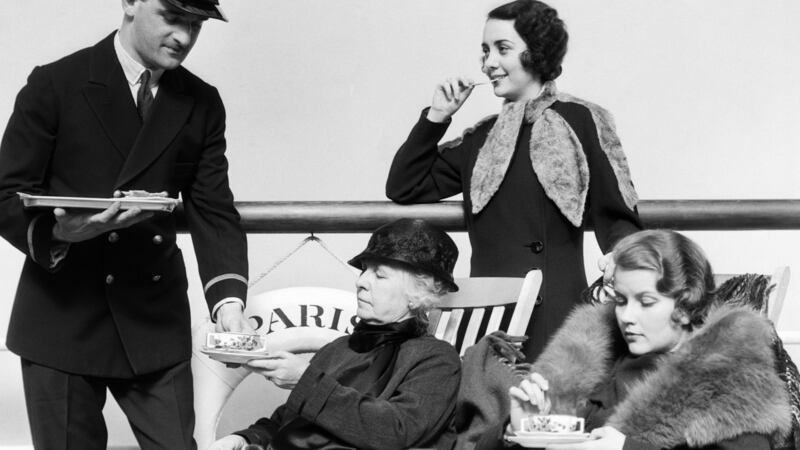 Three women being served tea by a steward on board an ocean liner crossing the Atlantic ocean in the 1920s. Photograph:   H. Armstrong Roberts/ ClassicStock/ Getty Images