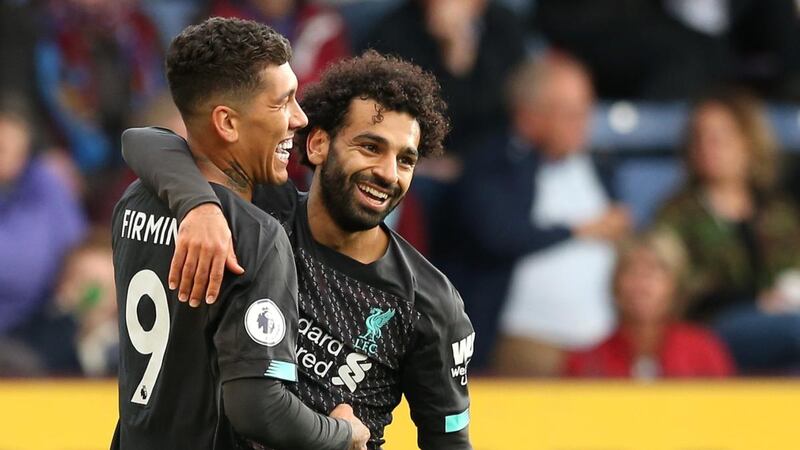Roberto Firmino celebrates with teammate Mohamed Salah after scoring Liverpool’s third goal. Photograph:  Jan Kruger/Getty Images