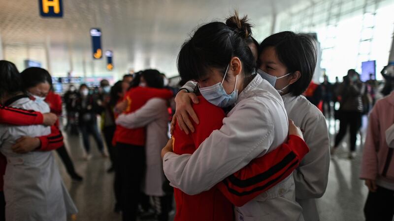 Departures: At Wuhan’s newly reopened Tianhe Airport, medical staff from Jilin province (in red) hug nurses from Wuhan before leaving the city. Photograph: Hector Retamal/AFP