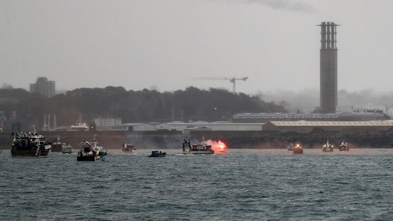 A flare is lit as French fishing boats protest in front of the port of Saint Helier off the British island of Jersey to draw attention to what they see as unfair restrictions on their ability to fish in UK waters after Brexit. Photograph: Sameer Al-Doumy/AFP via Getty