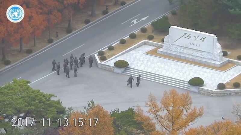 North Korean soldiers hold rifles and gather in the North Korean side of DMZ