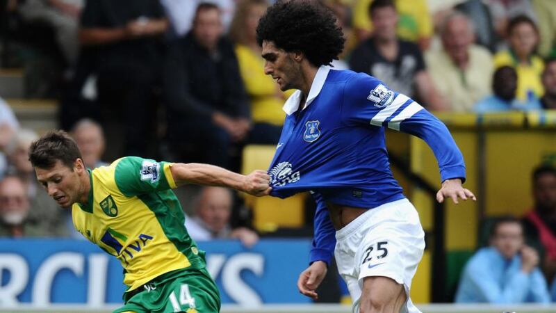 Wes Hoolahan  of Norwich City holds off a challenge from Marouane Fellaini of Everton  at Carrow Road. Photograph:  Tony Marshall/Getty Images