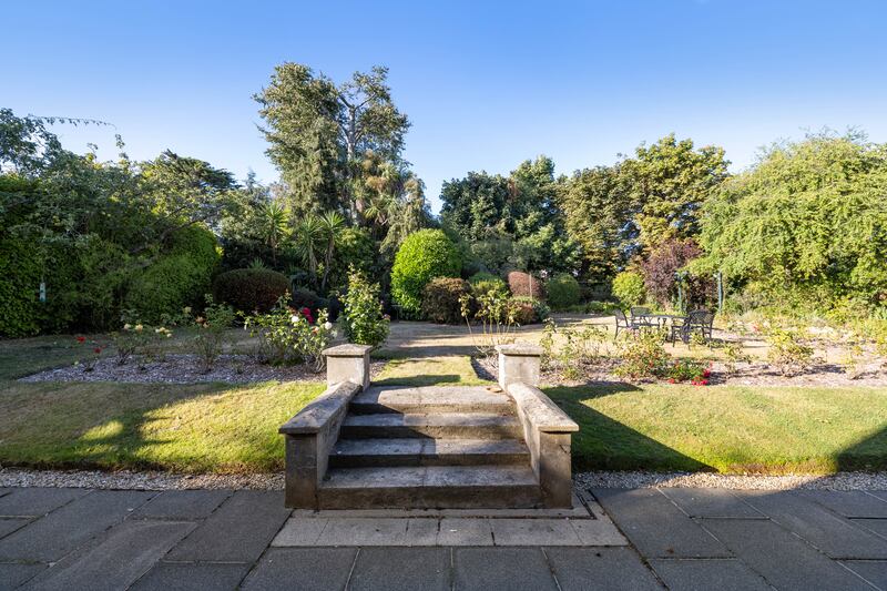 French doors open out to the rear garden's beautifully manicured greenery