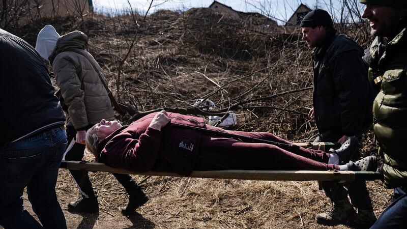 Men bore an older resident on a stretcher as some of the last remaining civilians in the villages of Irpin and Bucha, northwest of Kyiv, fled with the sounds of heavy fighting in the distance on Saturday, March 12, 2022.Photograph: Lynsey Addario/The New York Times