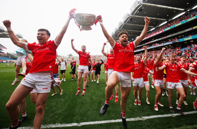 Liam Jackson and Conor Branigan lead the celebrations with the Delaney Cup after Louth's win over Meath. Photograph: Tom Maher/Inpho