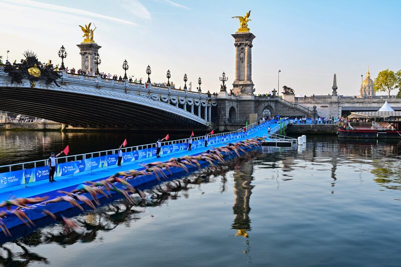 Triathlon athletes dive into the Seine next Pont Alexandre III. Photograph: Miguel Medina/AFP via Getty Images