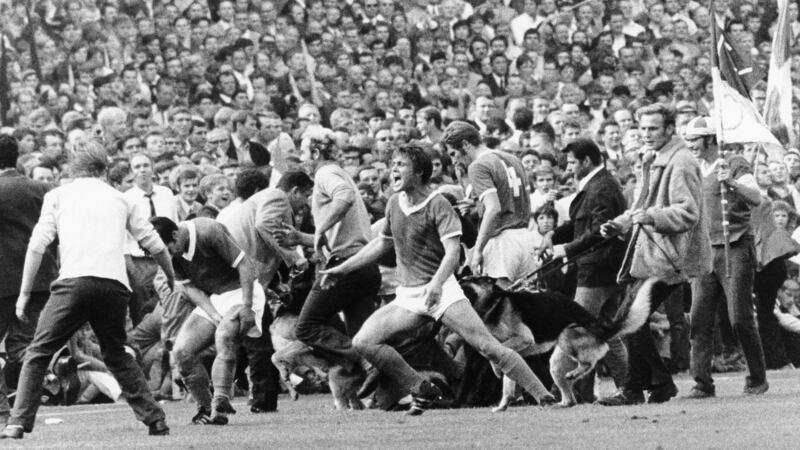 Schalke 04’s Friedel Rausch is bitten by a dog after fans invade the pitch following a Schalke goal in a 1969 Revierderby. Photograph: Horstmüller/Ullstein Bild via Getty Images