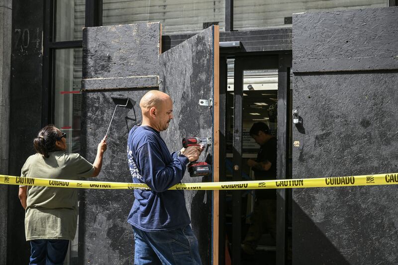 A plywood door is installed outside a damaged pharmacy in downtown Los Angeles on Tuesday. Photograph: Ronaldo Schemidt/AFP via Getty Images       