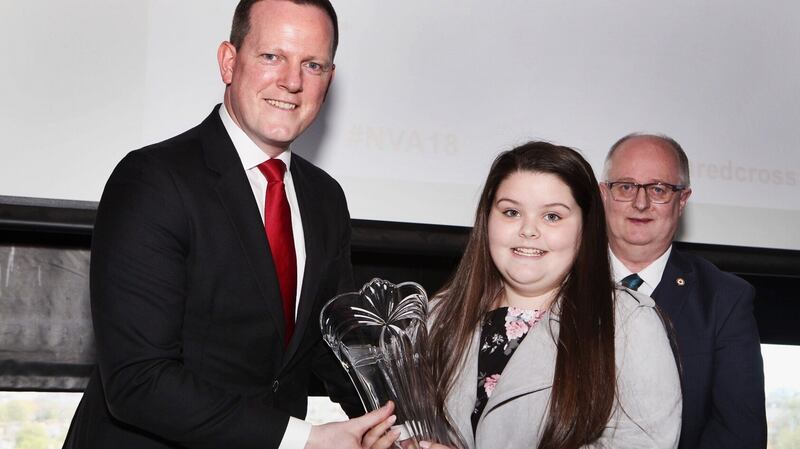 Fine Gael TD Alan Farrell presents Sarah McConnellogue (12), with her award for being Irish Red Cross young volunteer of the year. Photograph: Claire Nash