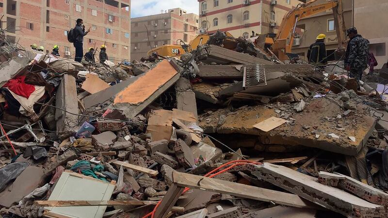 Emergency workers sift through the rubble of the collapsed apartment building. Photograph: Mohamed Salah/AP