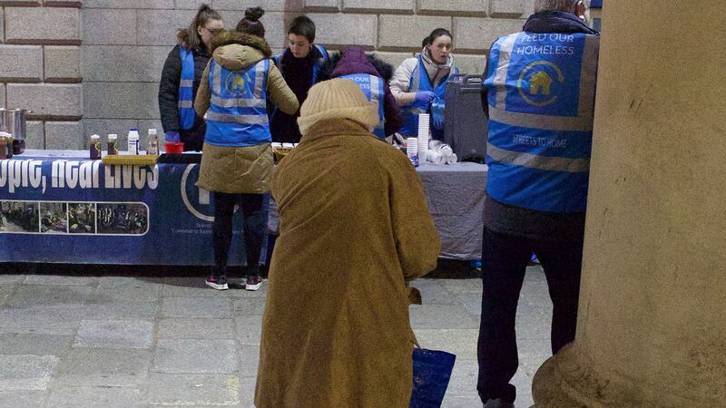 An elderly woman watches as the Feed Our Homeless charity provides help at College Green in Dublin. Photograph: Damien Eagers