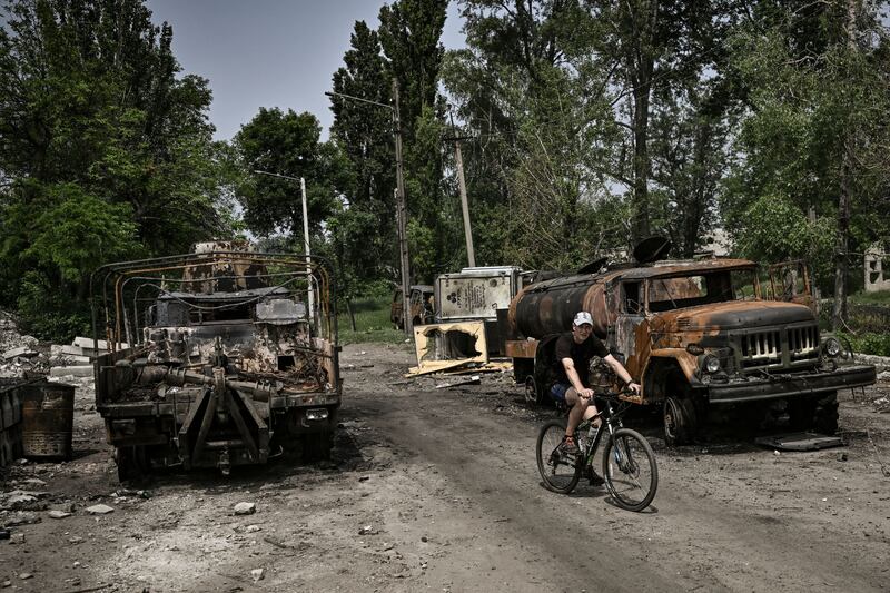 A man rides his bicycle between two destroyed military trucks in the city of Lysychansk in eastern Ukrainian region of Donbas on Saturday. Photograph: Aris Messinis/AFP via Getty Images