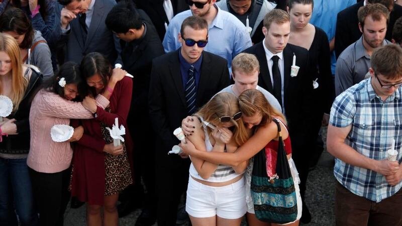 Students comfort each other during a candlelight vigil held to honor the victims of Friday night’s mass shooting. Photograph: Getty