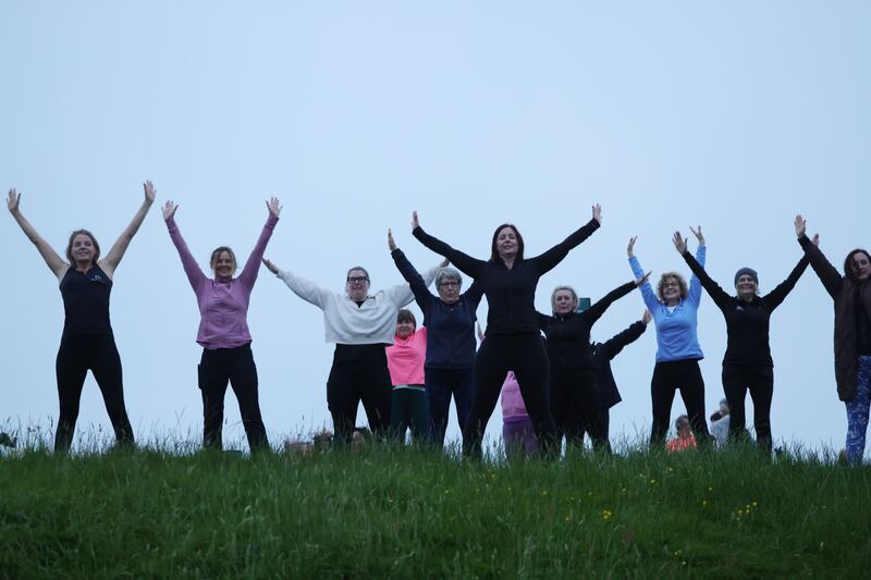Michelle O'Brien of Haven Studios leads a Pilates group on their fifth straight early-morning class  on a grassy mound at the Hill of Tara, to mark the solstice. Photograph: Alan Betson/The Irish Times

