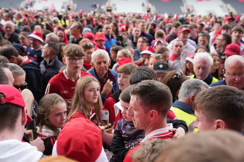 Cork's Pat Horgan and his son Jack make their way through the Cork throngs following the league final win over Tipperay in Cork. Photograph: James Lawlor/Inpho 