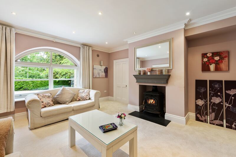 A modest-sized livingroom opens off to the left of the entrance hallway, with solid fuel stove in the fireplace. 