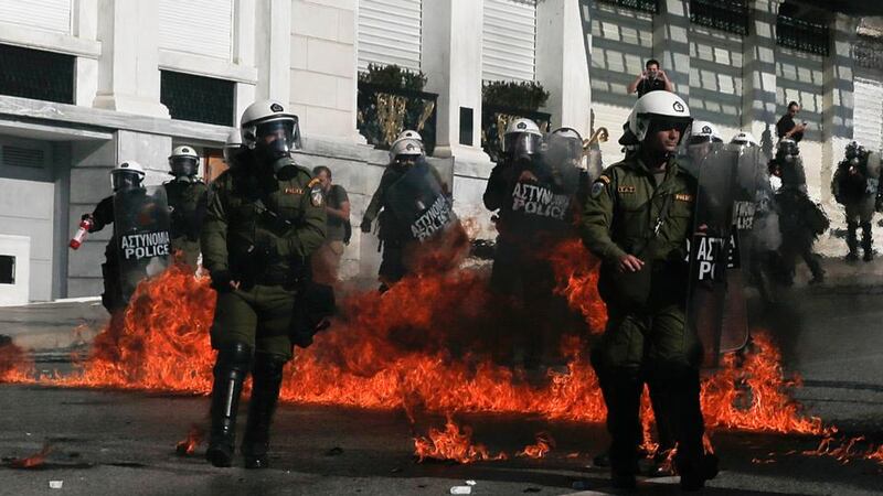 Riot policemen walk by fires caused by petrol bombs thrown by youths following clashes between police and protesters in central Athens. Photograph: Alkis Konstantinidis/Reuters