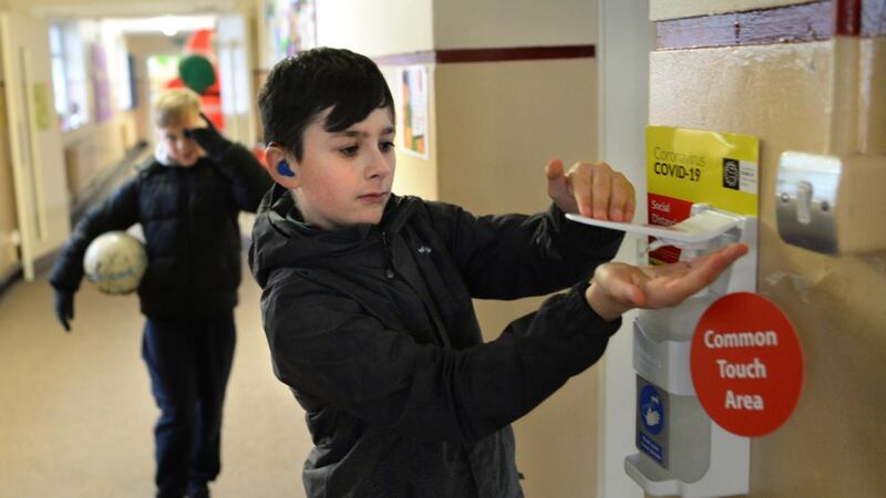 Nathan Ryan using hand sanitiser before entering the classroom. Photograph: Dara Mac Dónaill