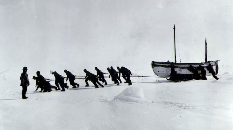 The crew hauling the James Caird, after their ship the Endurance broke up, with Shackleton looking on. Photograph: PA